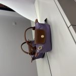 Çantë Longchamp Le Pliage Mini lila on white surface.