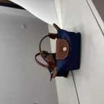 Çantë Longchamp Le Pliage Mini blu marine on white surface.