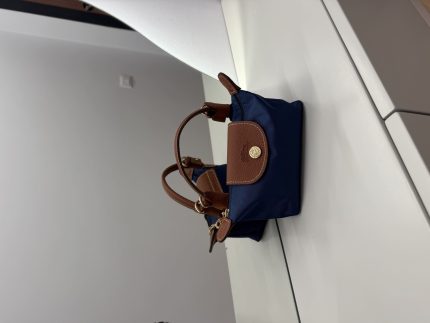 Çantë Longchamp Le Pliage Mini blu marine on white surface.