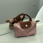 Dizajni i çantës Longchamp Le Pliage Mini roze me akcentet prej lëkure të kafshës.