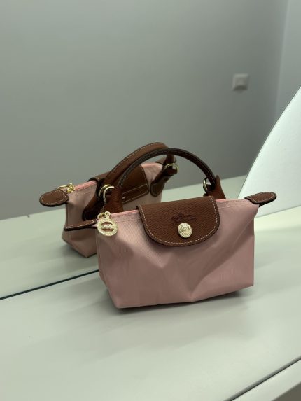 Dizajni i çantës Longchamp Le Pliage Mini roze me akcentet prej lëkure të kafshës.