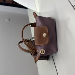 Çantë Longchamp Le Pliage Mini mauve on white surface.