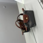 Çantë Longchamp Le Pliage Mini gri on white surface.
