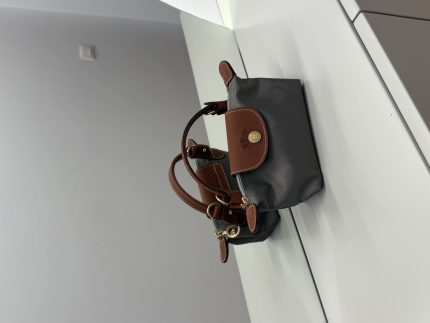 Çantë Longchamp Le Pliage Mini gri on white surface.