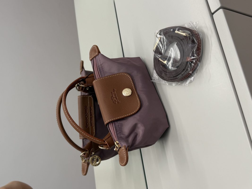 Çantë Longchamp Le Pliage Mini, elegant purple bag with brown leather accents.