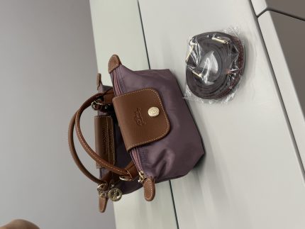Çantë Longchamp Le Pliage Mini, elegant purple bag with brown leather accents.
