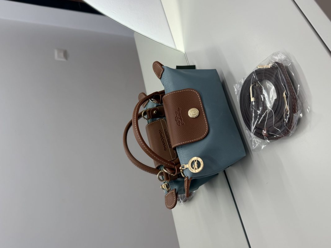 Çantë Longchamp Le Pliage Mini, blu dhe kafe, me rrip të ndashëm.