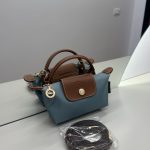Çantë Longchamp Le Pliage Mini, blu dhe kafe, me rrip të ndashëm.