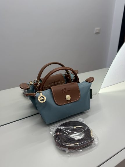 Çantë Longchamp Le Pliage Mini, blu dhe kafe, me rrip të ndashëm.