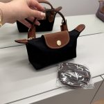 Çantë longchamp le pliage mini e zezë me rrip dhe doreza të kafe.