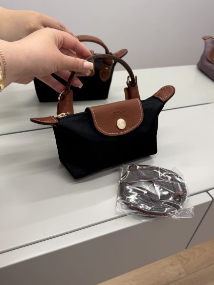 Çantë longchamp le pliage mini e zezë me rrip dhe doreza të kafe.