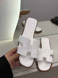 Hermes Oran Flat white sandals for women on display.