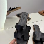 Hermes Oran Flat black sandals for women on display.