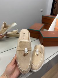 Loro Piana women's beige loafers with gold accents on display.
