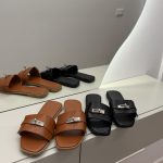 Louis Vuitton brown and black mules on display.
