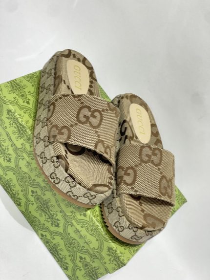 Gucci GG monogram slides on green patterned box for women.