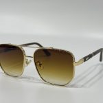 Gold-framed Dita sunglasses with gradient lenses on white background.