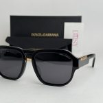 Dolce & Gabbana sunglasses with black frames and branded packaging.