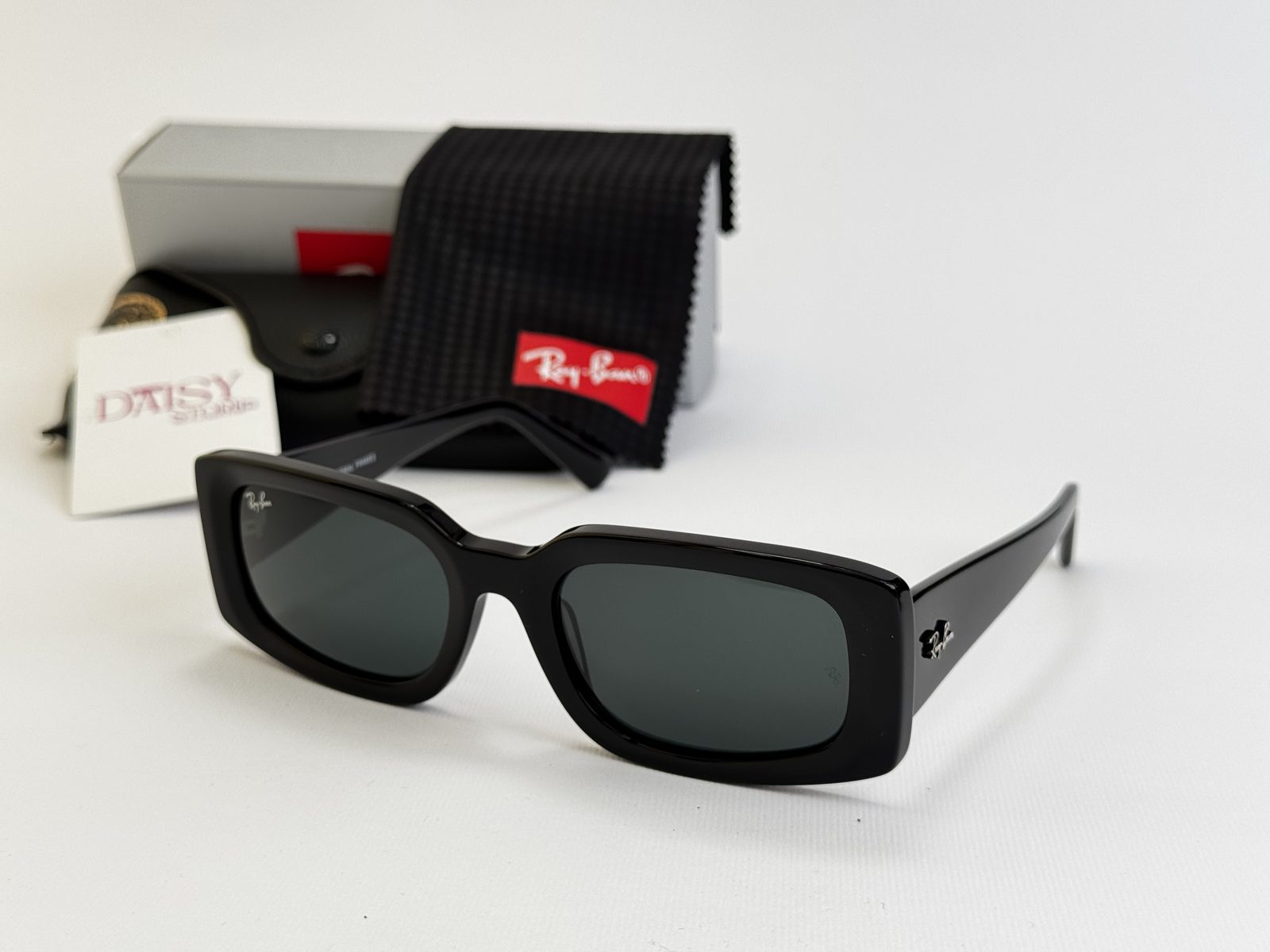 rayban-20kryesore Ray-Ban sunglasses with black frame and accessories displayed.