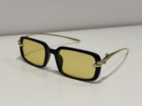 Bottega Veneta sunglasses with yellow lenses and black frame.
