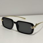 Bottega Veneta sunglasses with black frames and gold temples.
