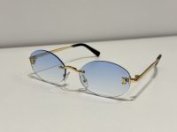 Cartier rimless sunglasses with gold frames and blue lenses.