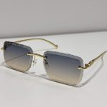 Textured square Cartier sunglasses with gold frames on white background.
