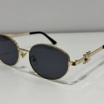 Celine oval sunglasses, gold frame, black lenses, elegant design.
