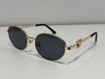 Celine oval sunglasses, gold frame, black lenses, elegant design.