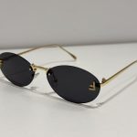 Fendi rimless sunglasses, elegant gold frame, dark lenses.