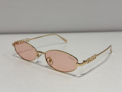 GUCCI oval sunglasses with pink lenses and gold frame elegance.