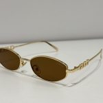 GUCCI oval sunglasses, gold frame, brown lenses, luxury eyewear.
