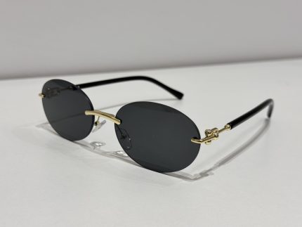 Rimless oval sunglasses with black lenses and gold accents.