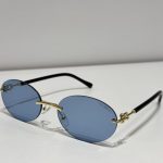 Tiffany & Co rimless sunglasses with blue lenses and gold accents.