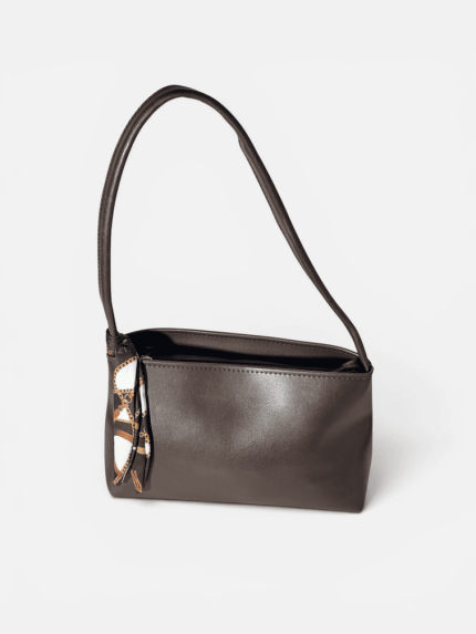 Elegant brown women's handbag with patterned scarf accent.