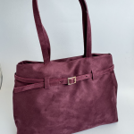 Elegant burgundy women's handbag with strap and buckle detail.