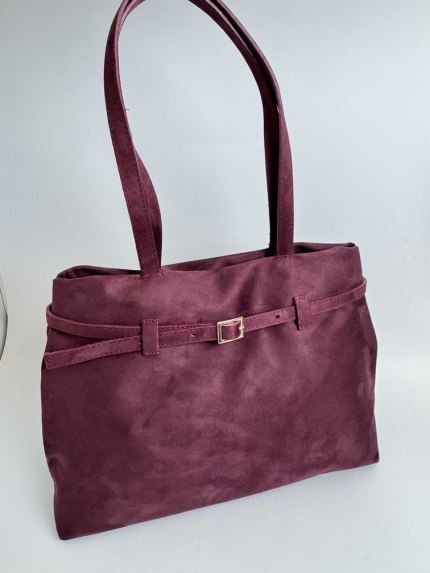 Elegant burgundy women's handbag with strap and buckle detail.