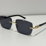 Elegant Cartier women's sunglasses with gold accents and dark lenses.