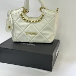 Çantë moderne për femra CHANEL, dizajn elegant e bardhë me detaje ari.