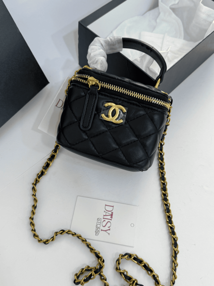 Chanel Vanity black quilted handbag with gold chain and logo.