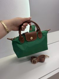 Green Longchamp handbag with brown leather accents and strap.