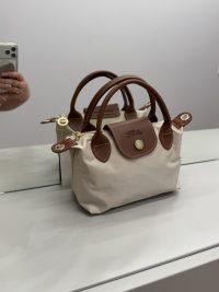 Çantë Femrash Longchamp beige handbag with brown leather handles.