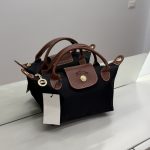 Çantë Femrash Longchamp black handbag with brown leather handles.