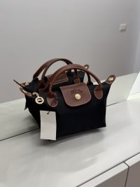 Çantë Femrash Longchamp black handbag with brown leather handles.
