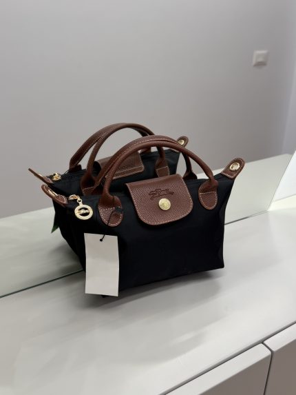 Çantë Femrash Longchamp black handbag with brown leather handles.