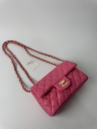 Pink Chanel classic quilted handbag with gold chain strap.