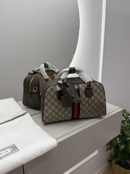 Gucci Ophidia Duffle bag with signature pattern and green-red stripe.