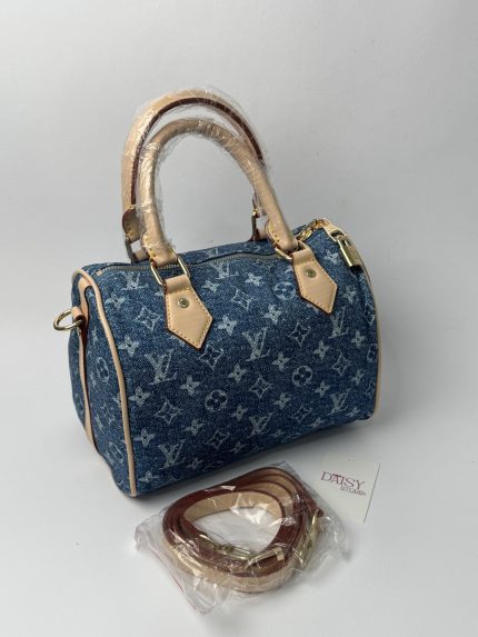 Blue denim handbag with beige handles and detachable strap.