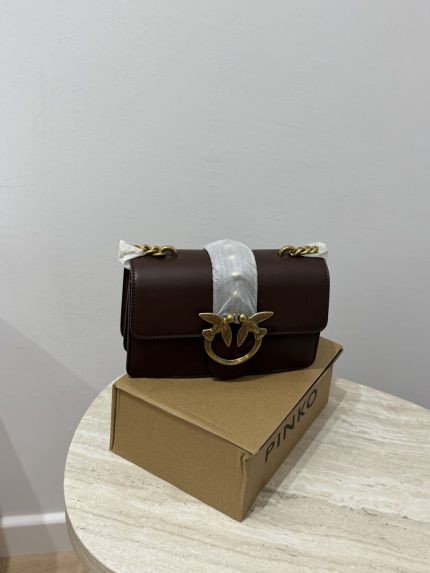 Chanel Vanity Case për Femra, elegant brown handbag on table.