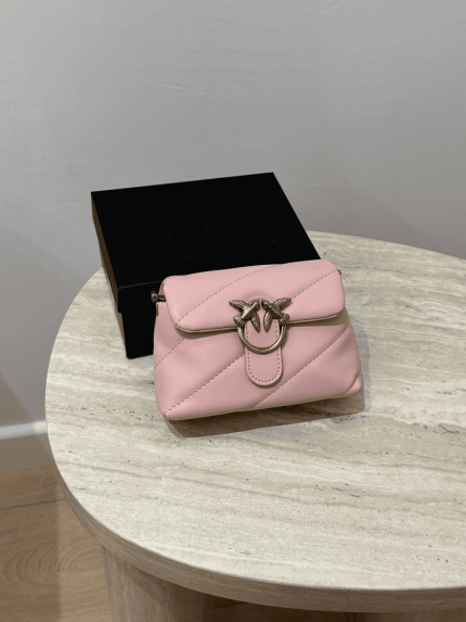 Pink Love Mini Puff handbag on marble table.